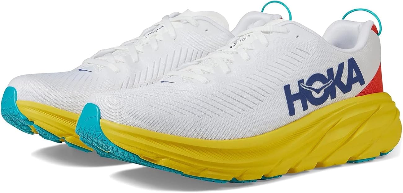 Un paio di scarpe da corsa Hoka Rincon 3 con tomaia bianca, logo blu, intersuola gialla, suola turchese e accenti rossi vicino al tallone.
