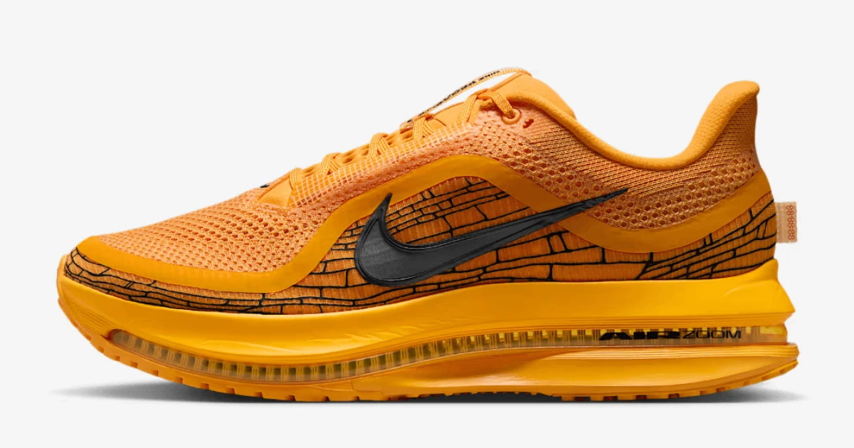 Una sneaker Nike Air Max Zoom arancione con swoosh nero e linee nere, su sfondo bianco.